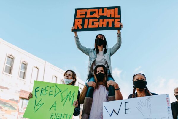 Symbolbild zum Weltfrauentag 2022: eine diverse Gruppe junger Menschen hält Plakate.